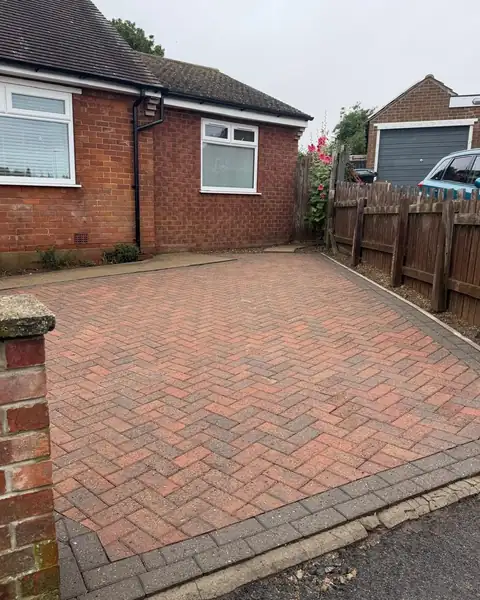 After: the same block paving driveway cleaned by AGP, the red herringbone pattern bright again.