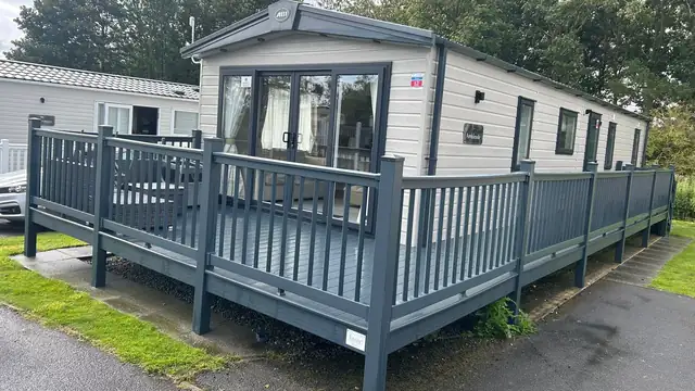 A freshly cleaned static caravan with its grey veranda decking.