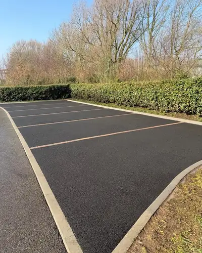After: the car park tarmac clean and dark, the bay lines crisp.